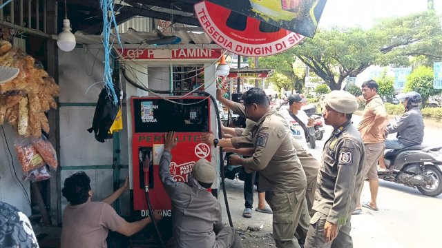 Petugas gabungan saat mengevakuasi salah satu fasilitas dagang milik PKL yang kedapatan melanggar batas fasilitas umum di sepanjang poros BTP, Kecamatan Tamalanrea.