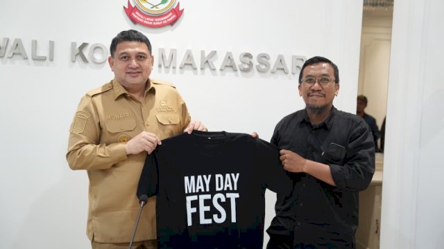 Wali Kota Makassar Munafri Arifuddin menerima kaus simbolis May Day Fest 2026 saat menerima audiensi panitia dan serikat buruh di Balai Kota Makassar untuk mematangkan persiapan dialog Hari Buruh di Lapangan Karebosi.