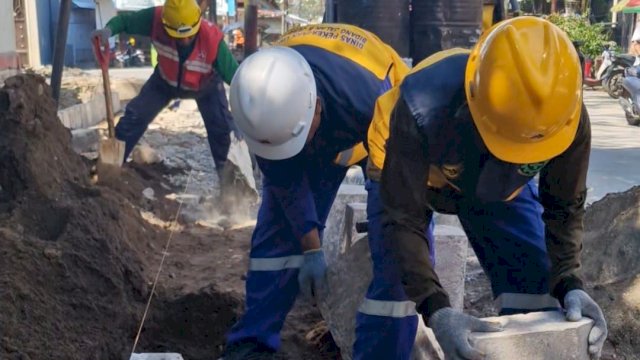 Petugas Dinas Pekerjaan Umum Kota Makassar tengah melakukan penataan trotoar di Jalan Tinumbu guna mengembalikan fungsi ruang publik dan mengoptimalkan sistem drainase, Kamis (25/6/2026).