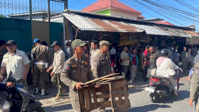 Personel Satpol PP bersama pemerintah kecamatan mengawal penertiban lapak di kawasan pasar tumpah Jalan AMD, Manggala, Kamis (2/7/2026).