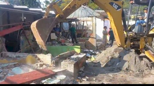 Pemerintah Kecamatan Mariso menurunkan alat berat untuk membantu pembongkaran lapak pedagang kaki lima yang menggunakan konstruksi permanen.