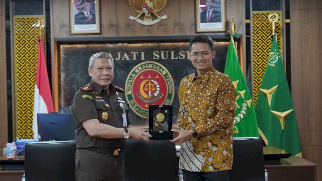 Kepala Kejaksaan Tinggi Sulawesi Selatan Muhammad Syarifuddin, S.H., M.H. menyerahkan plakat kepada General Manager PLN UIP Sulawesi I Gusti Made Aditya San Adinatha